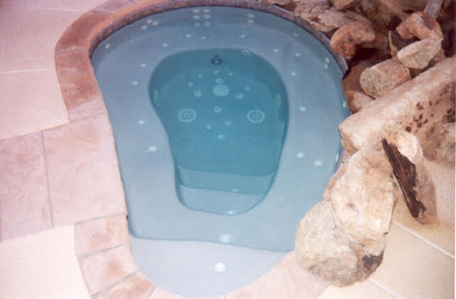 Custom built-in spa with therapy jets, bench seating, and stone edging in Arizona